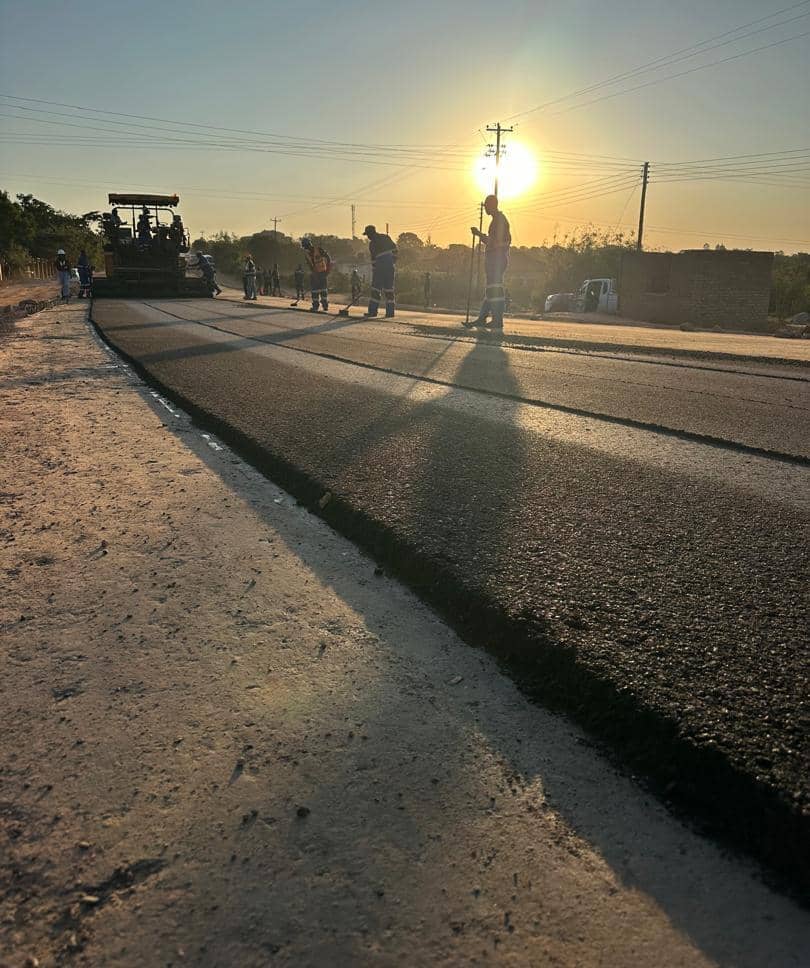 Rural highway road paving at sunset